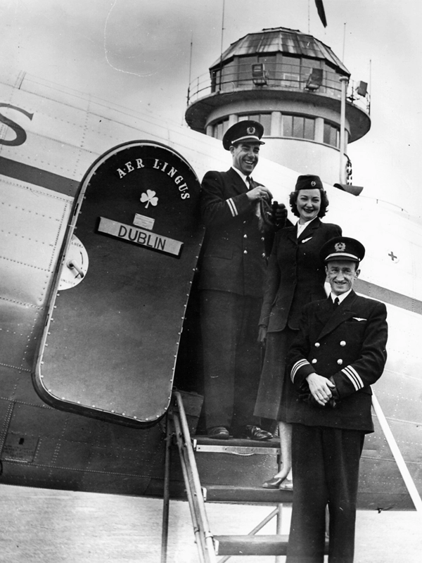 historic aer lingus pilots and flight attendant next to plane