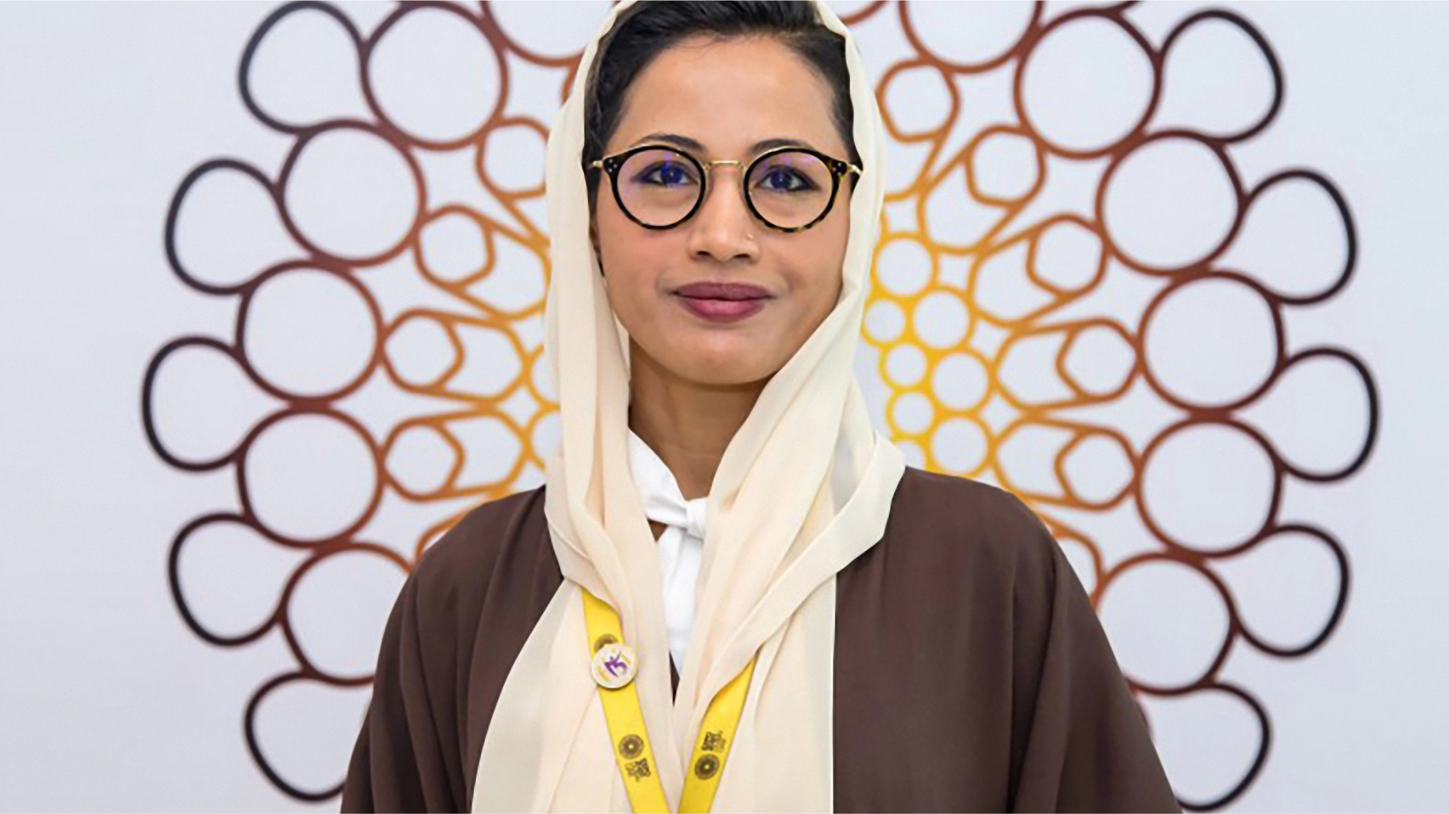 woman smiling with expo 2020 dubai logo behind her