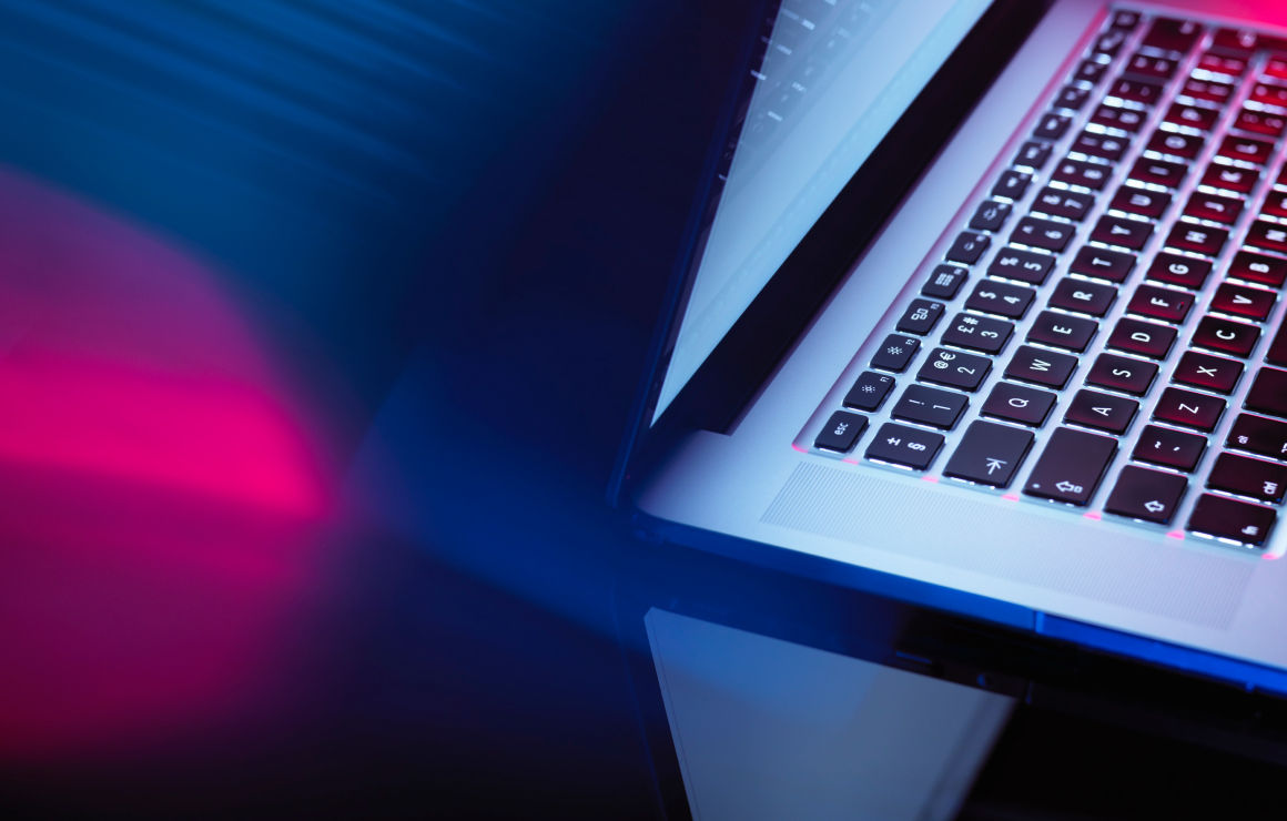 Close up of a laptop with blurry night lights background.
