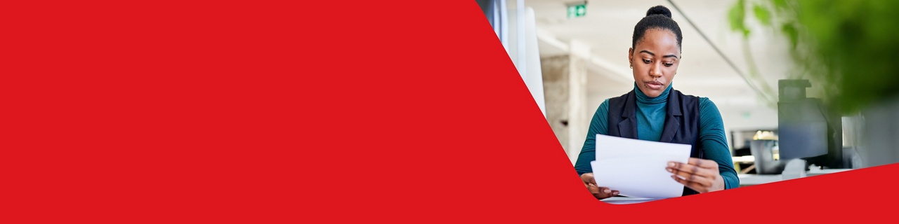 Photo of a woman consulting the documentation related to her Mastercard credit cards no longer offered to business clients