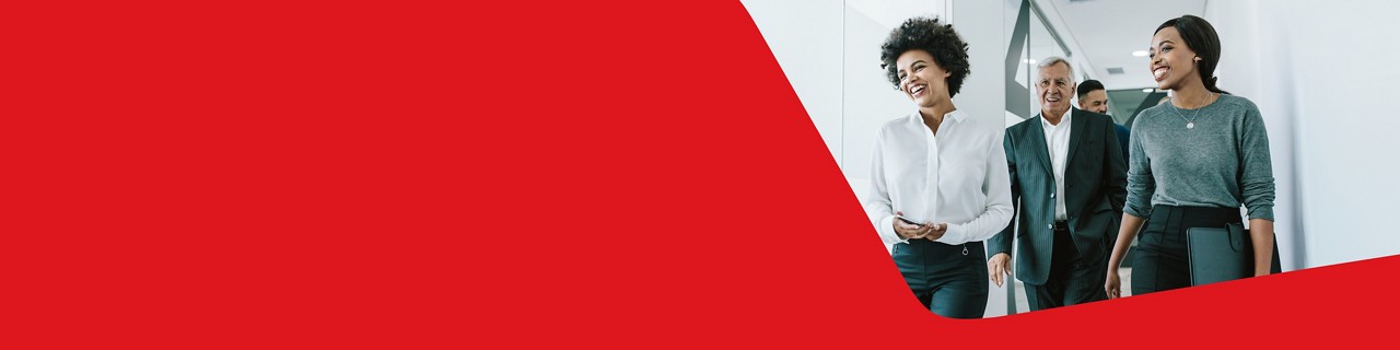 Photo de la direction d’une grande entreprise marchant dans un corridor de bureau, ravie par les services de la Banque Nationale 