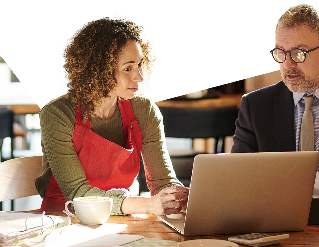 Photo of an entrepreneur and a National Bank account manager looking at financing solutions for businesses on a laptop in a coffee shop