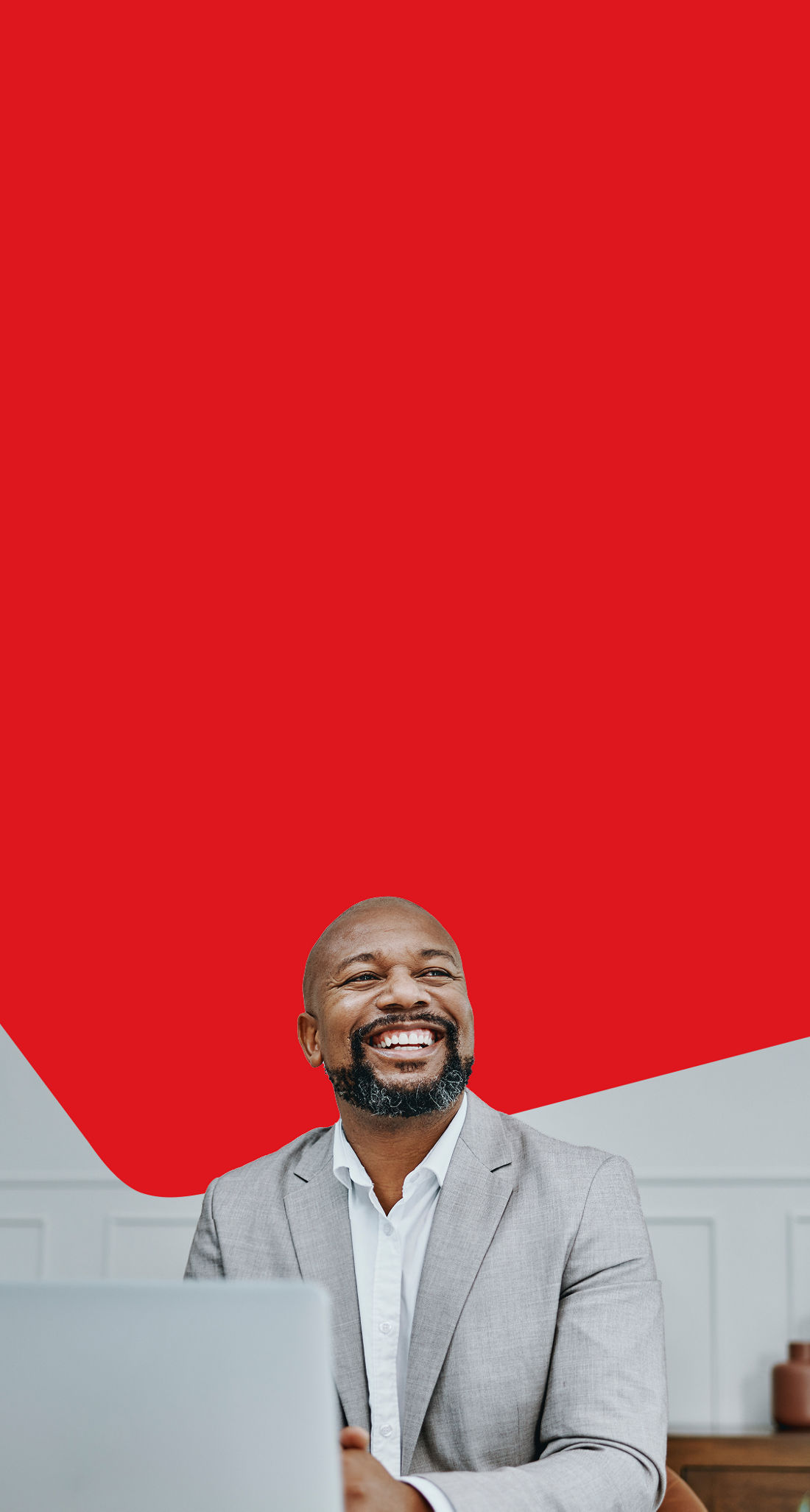 Photo d’un entrepreneur en complet gérant sa carte de crédit Mastercard Entreprise à son ordinateur 