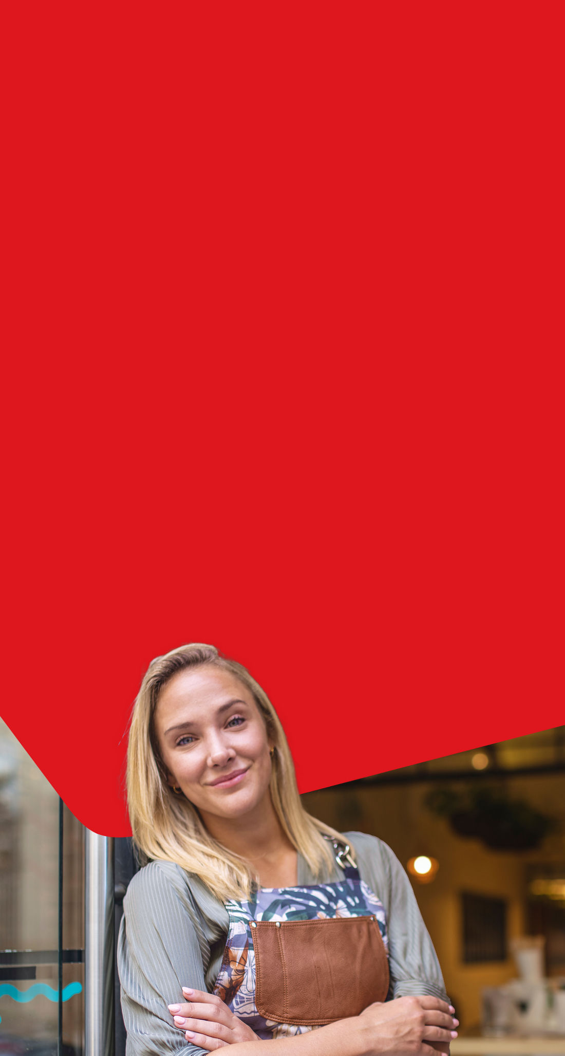 Photo d’une entrepreneure dans l’entrée de son commerce qui sourit grâce aux avantages de la carte de crédit Mastercard Marge Affaires de la Banque Nationale