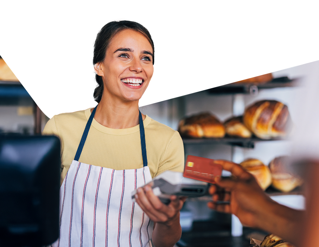 Photo d’une propriétaire de café faisant payer une personne avec un terminal de paiement Clover 
