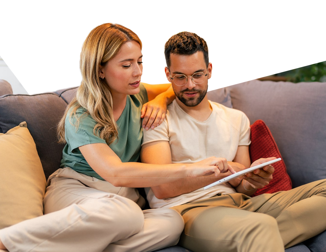 Photo of a couple learning the basics about mortgages by reading on their tablet