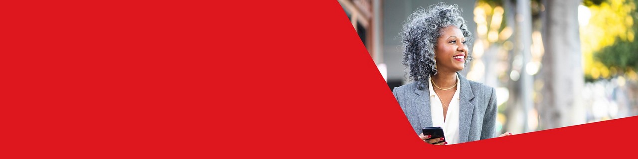 Photo of a businesswoman in an office happy to use her National Bank Business Mastercard credit card  