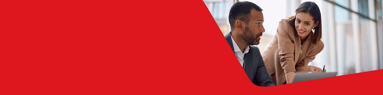 Photo d’un professionnel consultant les solutions de placements de la Banque Nationale sur son ordinateur, demandant des précisions à une conseillère 