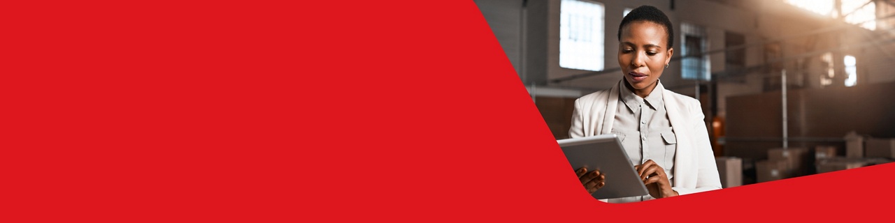 Photo d’une entrepreneure s’occupant de sa gestion bancaire au quotidien avec la Banque Nationale sur sa tablette dans un entrepôt