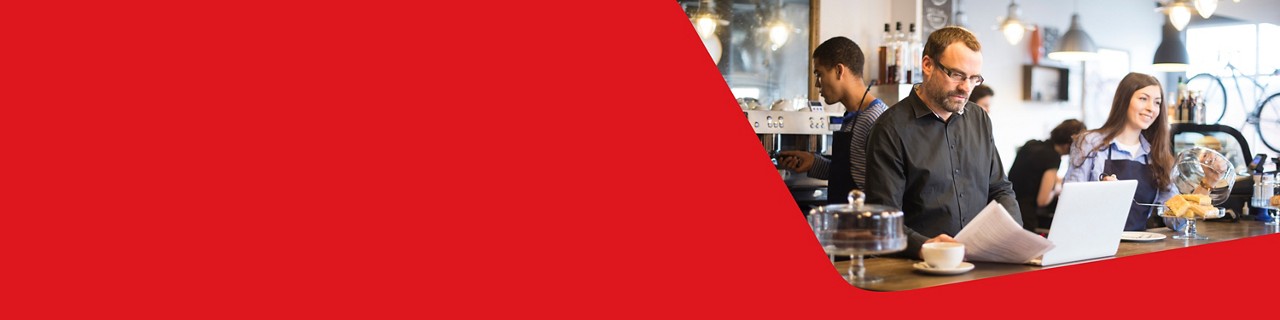 Photo d’un entrepreneur se renseignant sur les services de paie au comptoir de son restaurant 