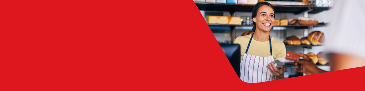 Photo of a coffee shop owner and a client completing a transaction with a Clover payment terminal 