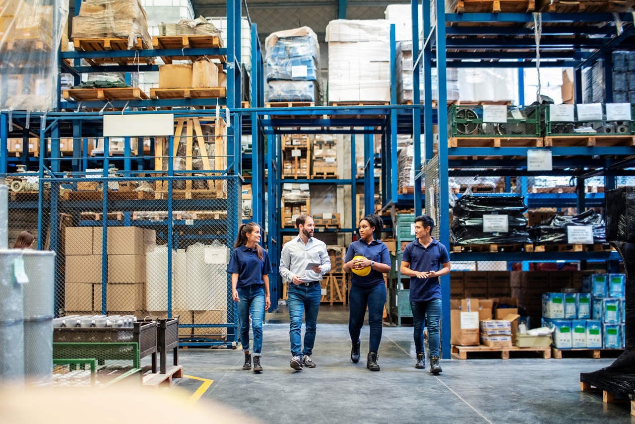 Photo of a group of people in a warehouse representing the benefits of invoice factoring 