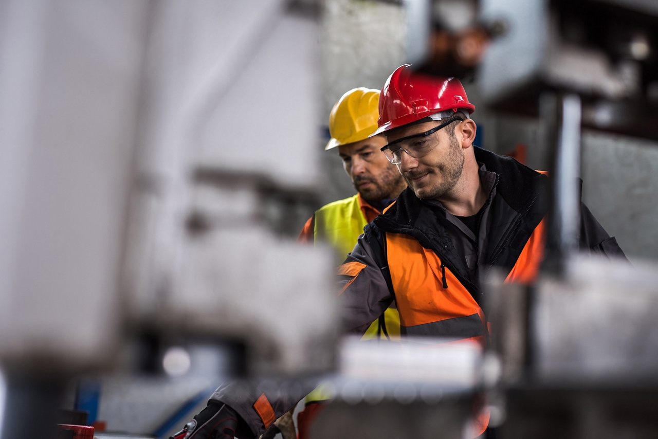 Photo of two equipment dealers working on fixing a vehicle