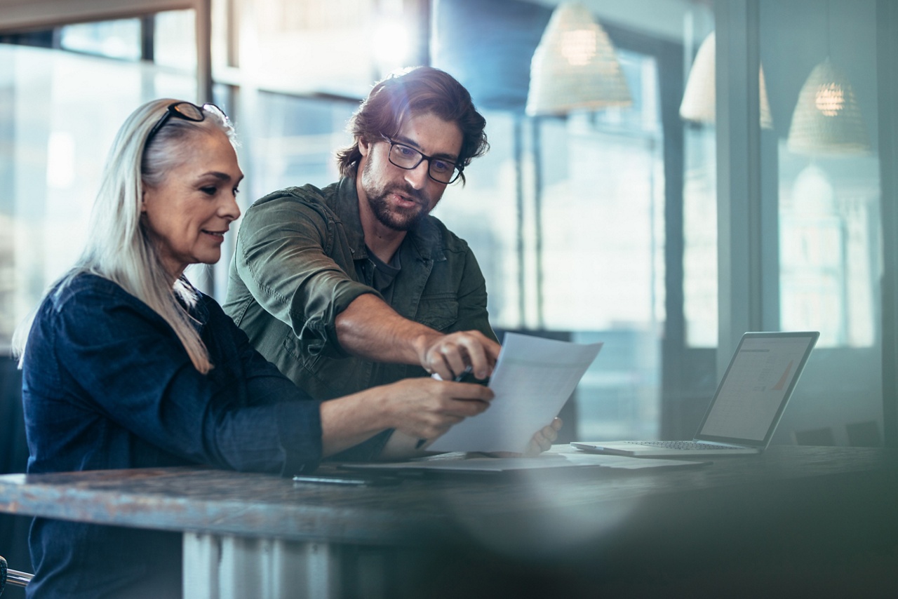 Photo of a tax expert showing a business owner how to file their taxes in Canada