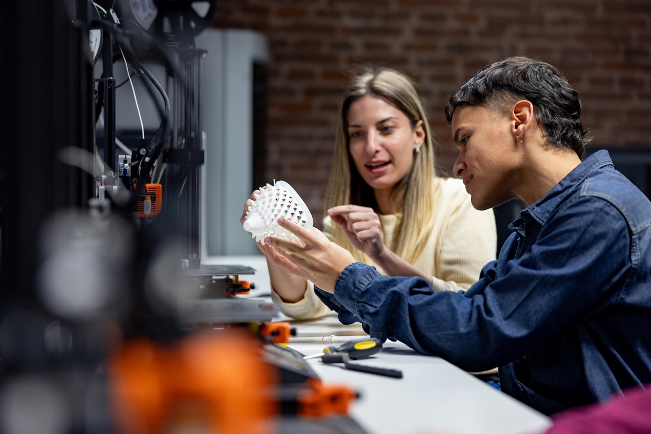 Photo de deux entrepreneurs regardant un prototype dans un atelier pour un article sur la protection de la propriété intellectuelle  