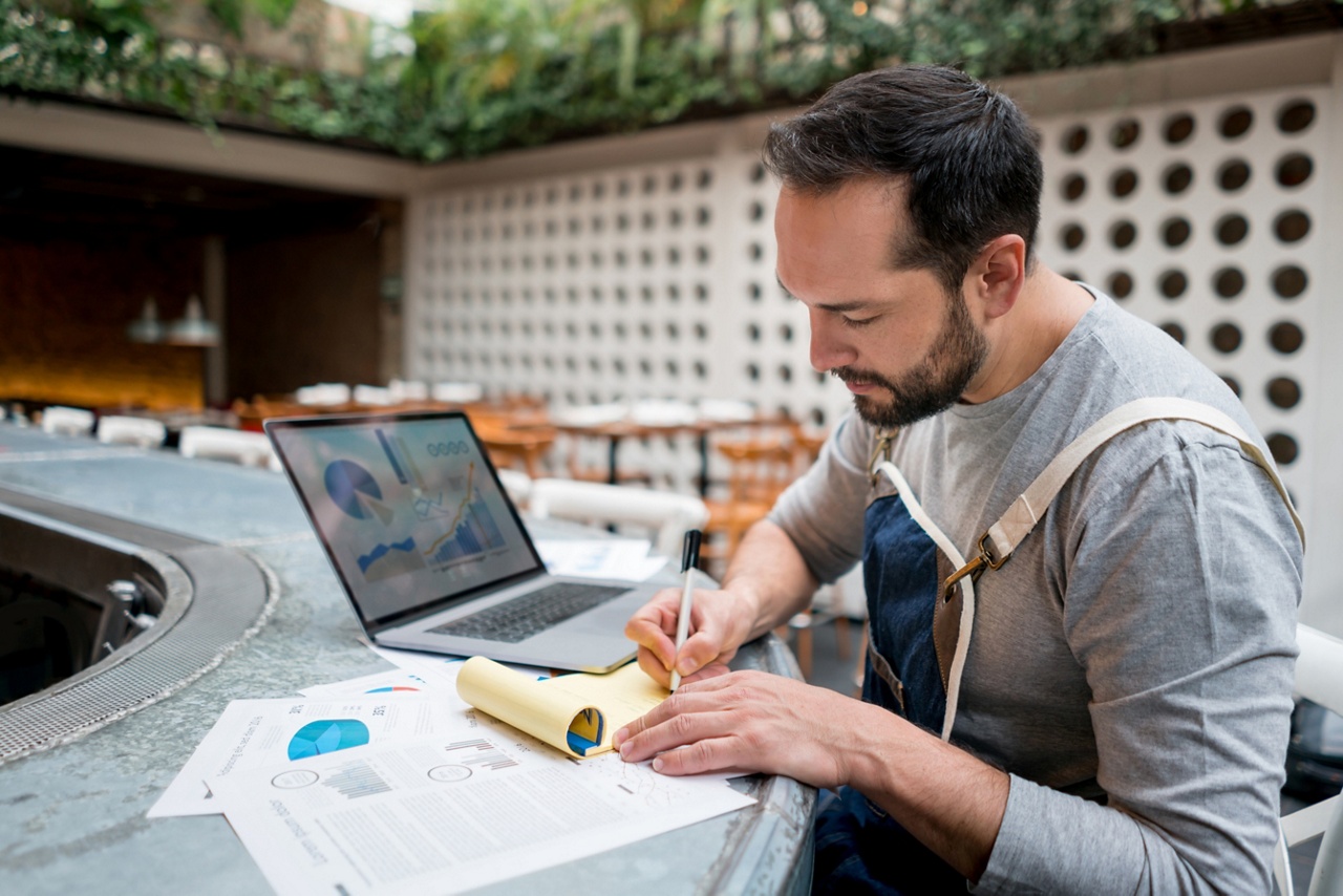 Photo of an entrepreneur on a patio writing out their business plan 