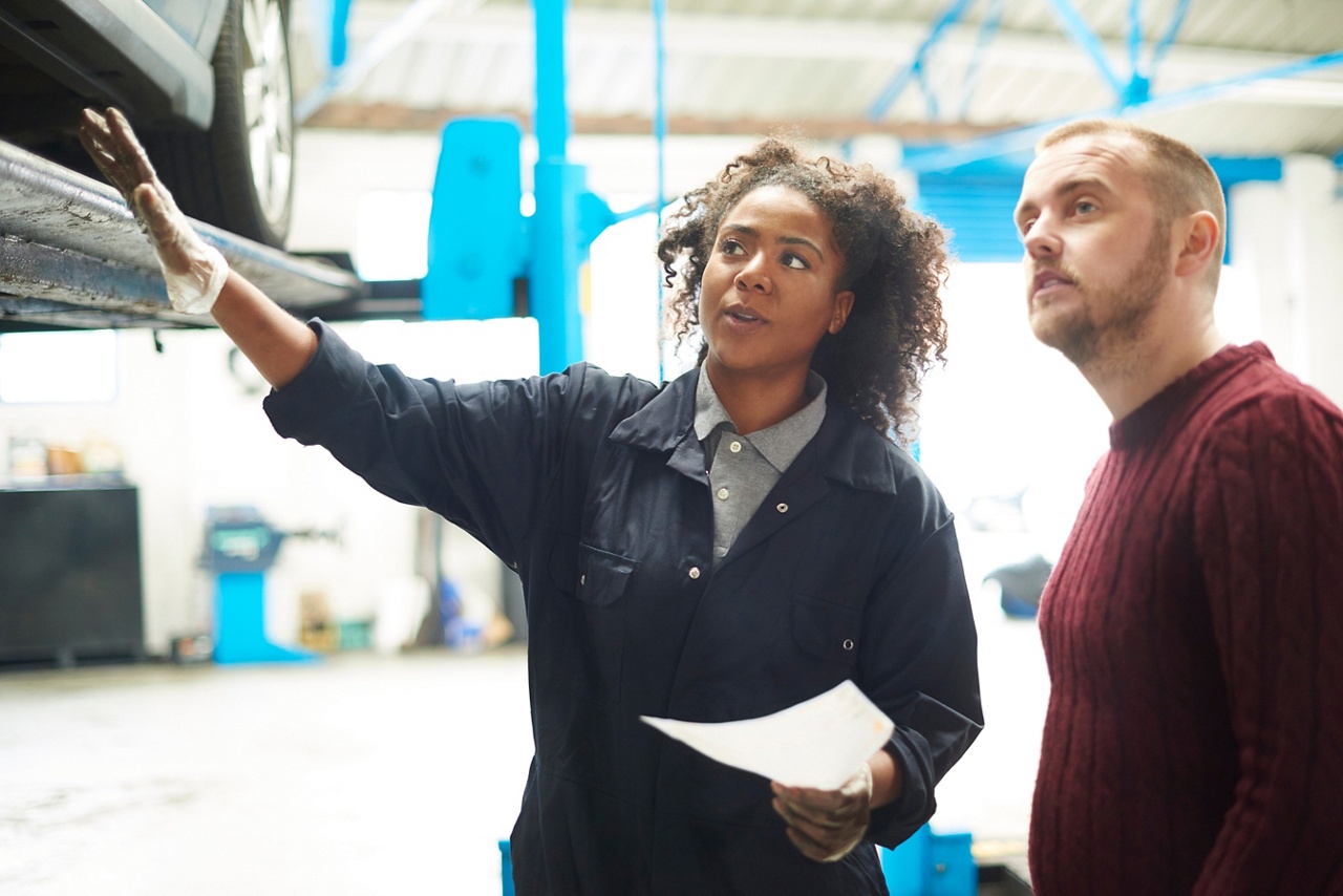 Photo of a mechanic and a client looking at a car representing identifying client needs 
