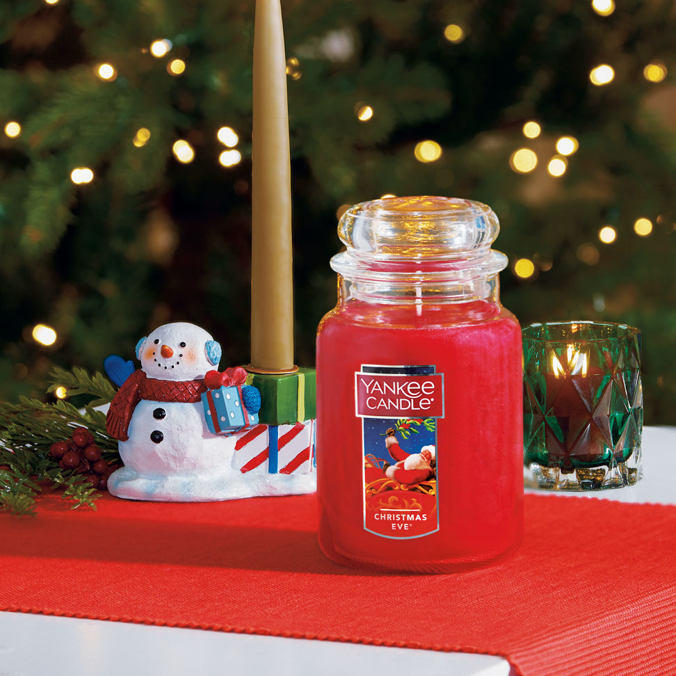 christmas eve large jar candle and bayberry taper candle on holder and votive candle with votive holder on table
