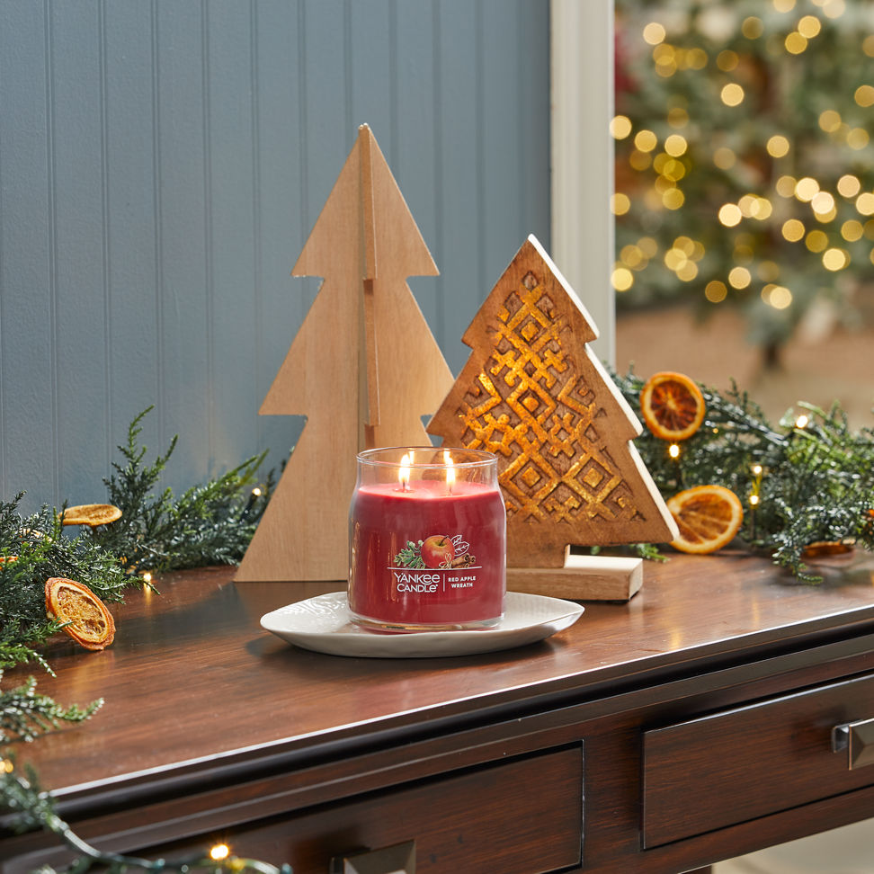 red apple wreath signature medium jar candle on desk