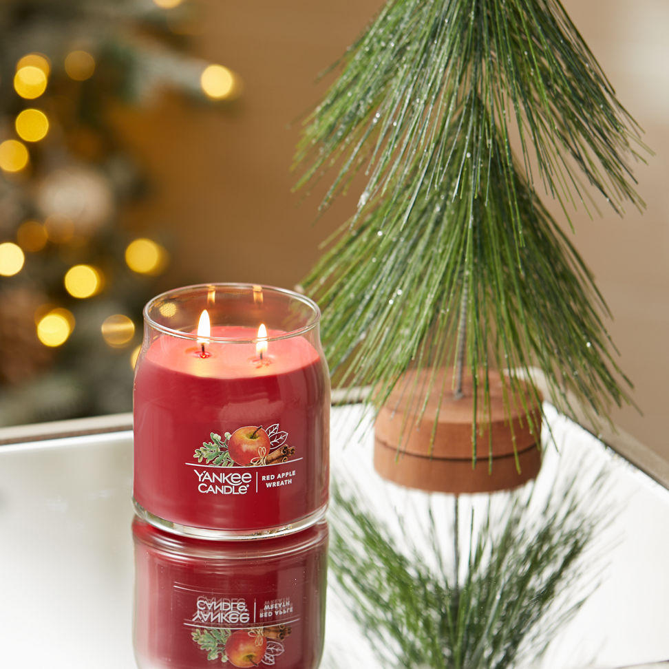 red apple wreath signature medium jar candle on table