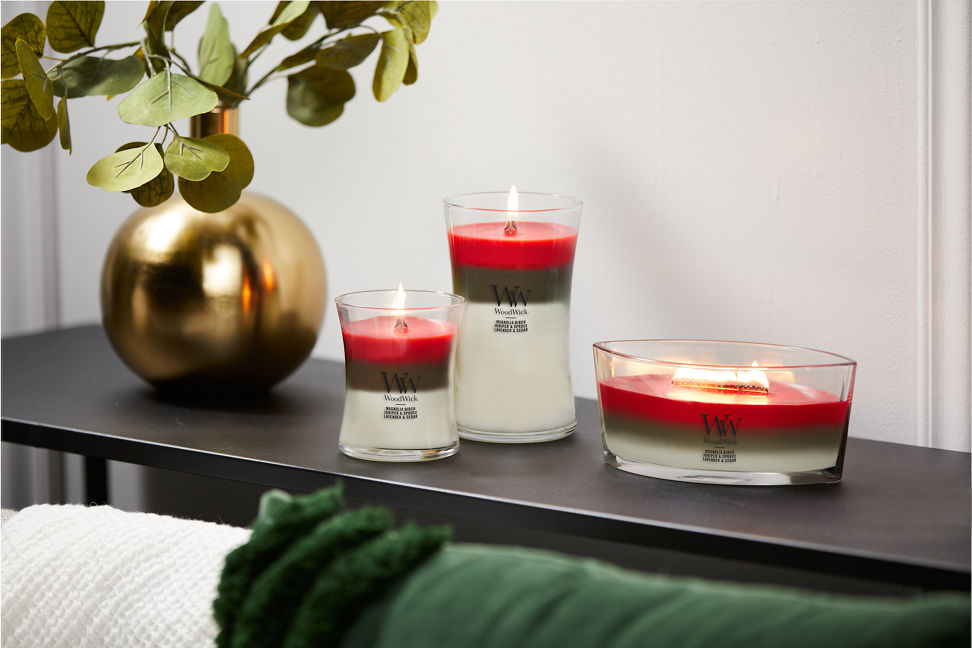 woodwick winter garland trilogy medium hourglass, large hourglass, and ellipse candles on shelf