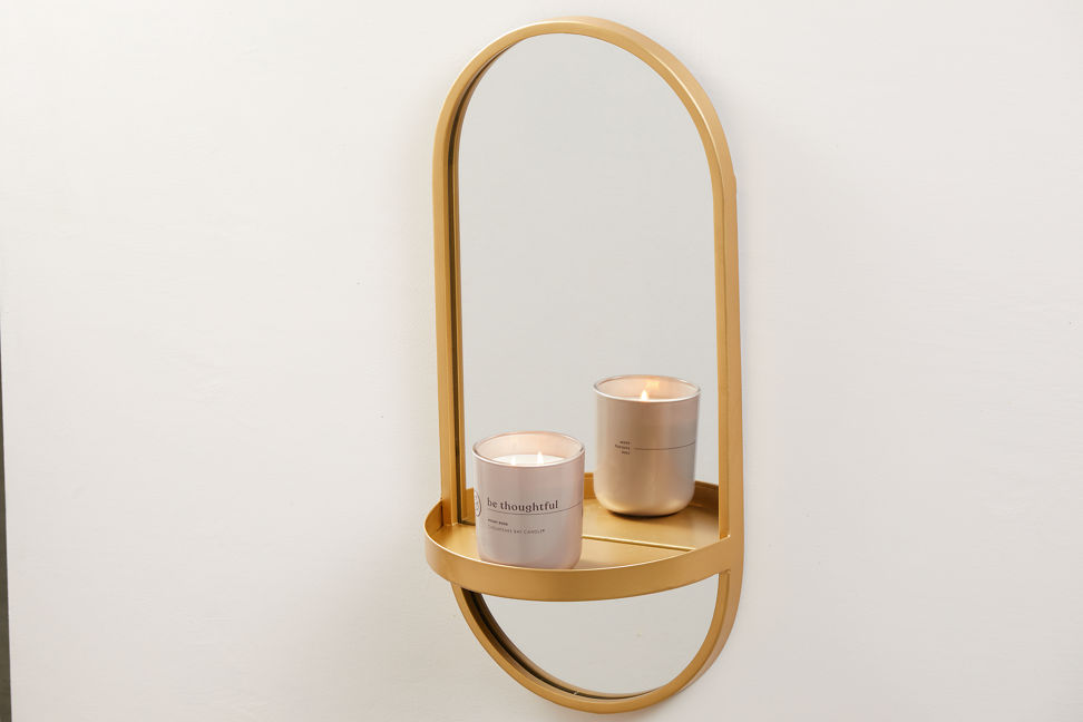 chesapeake bay candle intentions collection be thoughtful peony rose medium two wick jar candle on a golden mirror hanging on a wall