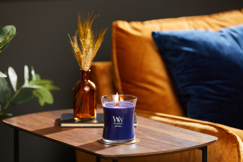 hinoki dahlia medium hourglass candle on brass coaster on wood side table next to easy chair