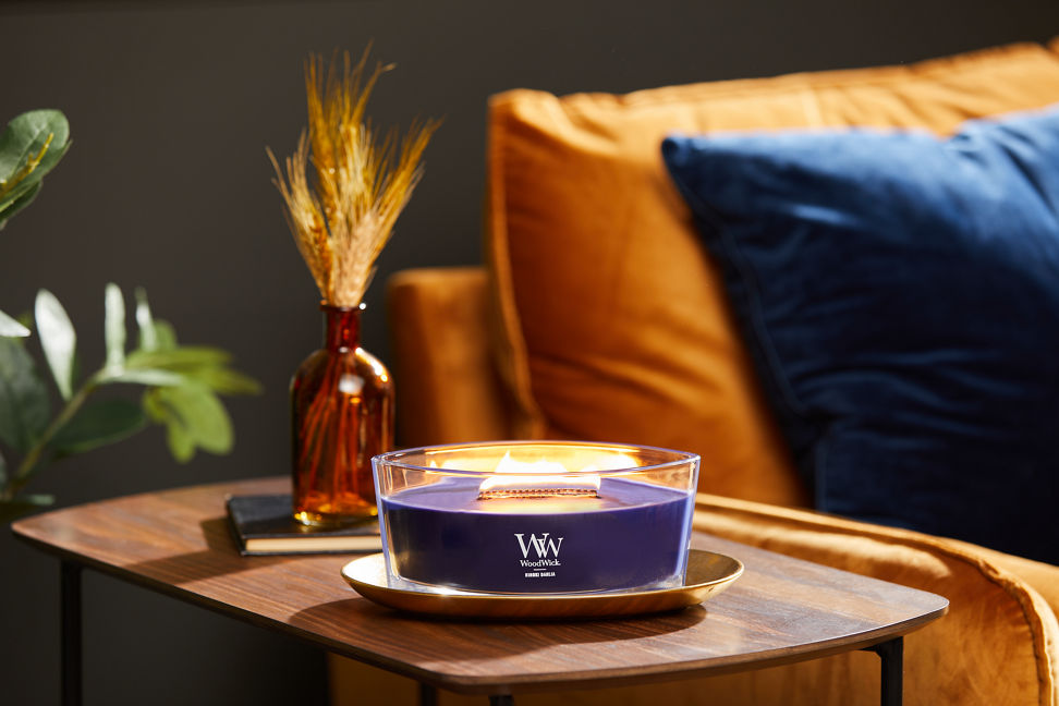 hinoki dahlia ellipse candle on brass tray on wood side table next to easy chair