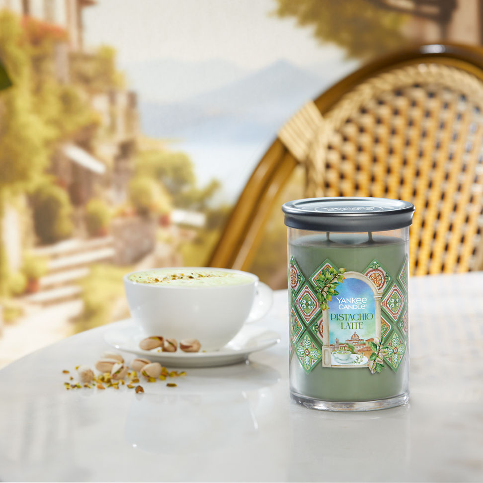 Hello, Italy! Collection Pistachio Latte Signature Large Tumbler Candle on a table next to pistachios and a latte