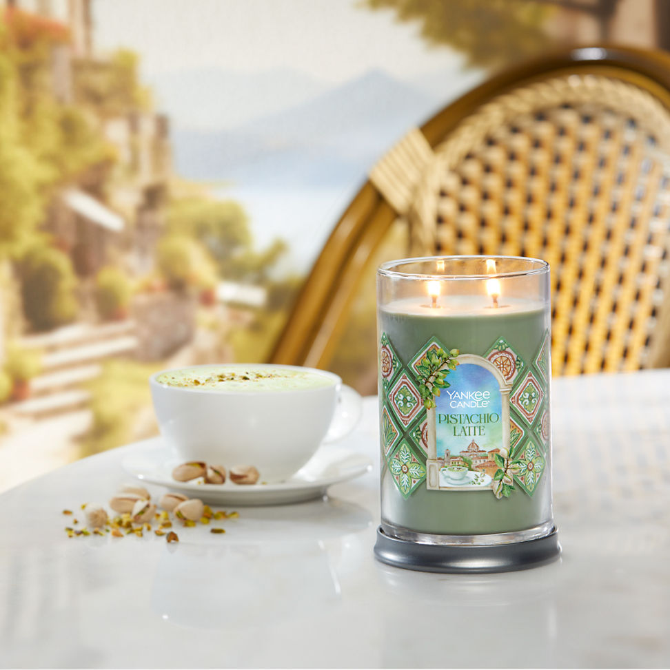 Hello, Italy! Collection Pistachio Latte Signature Large Tumbler Candle on a table next to a latte and pistachios