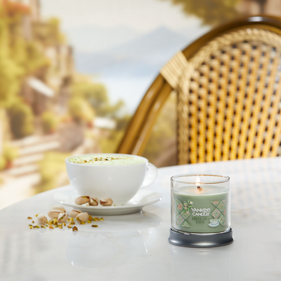 Hello, Italy! Collection Pistachio Latte Signature Small Tumbler Candle on a table with pistachios and a latte