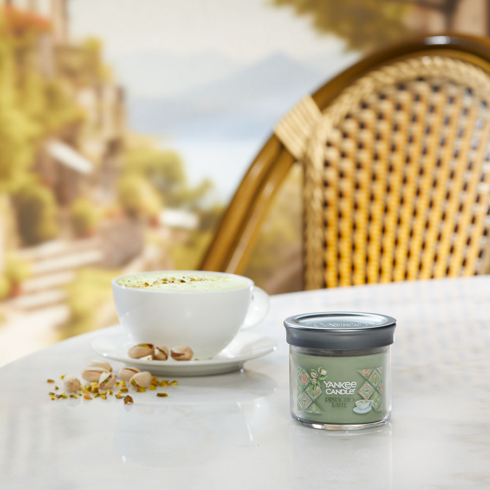 Hello, Italy! Collection Pistachio Latte Signature Small Tumbler Candle on a table with pistachios and a latte