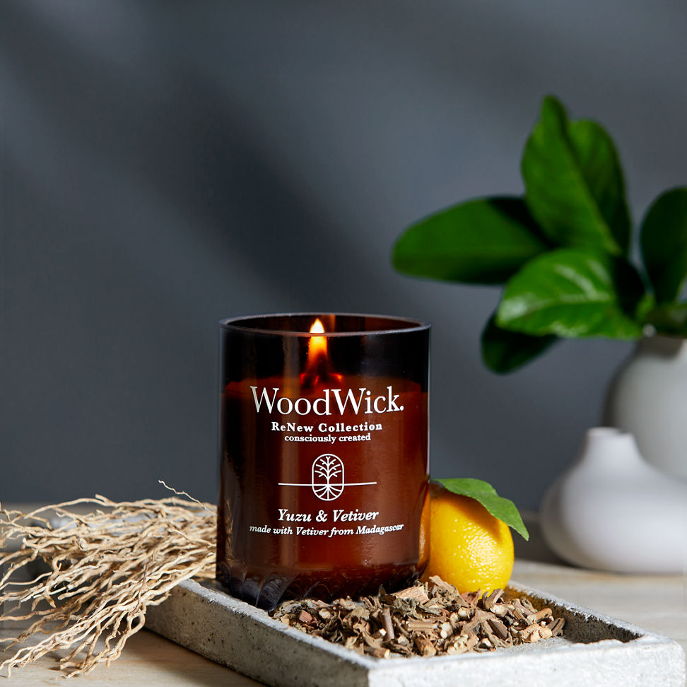 WoodWick ReNew Collection Yuzu & Vetiver Large Candle next to a lemon on a table