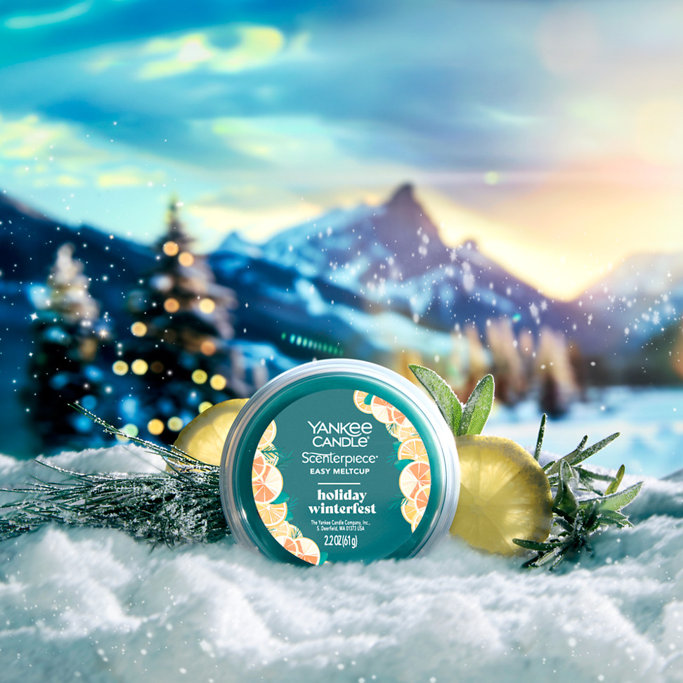holiday winterfest easy meltcup in snowy mountain scene with sliced citrus and herbs and evergreens