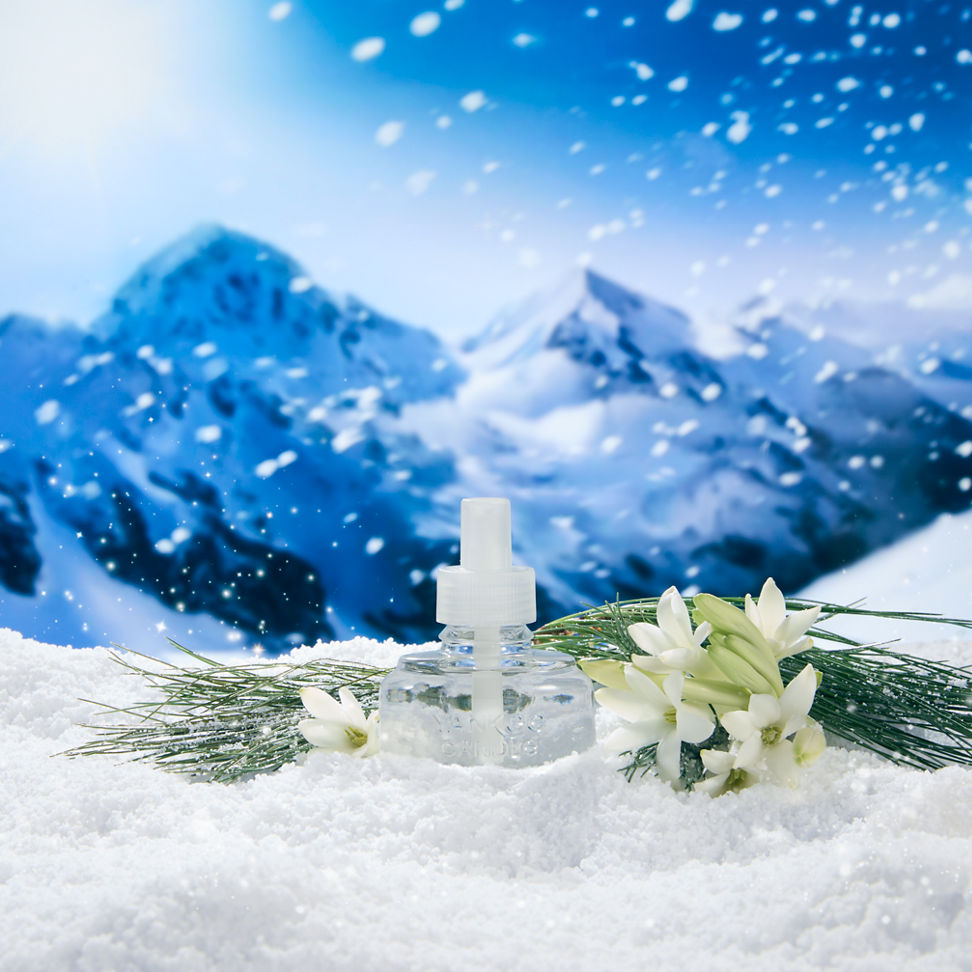 a ScentPlug Refill surrounded by snow, flowers, and mountains