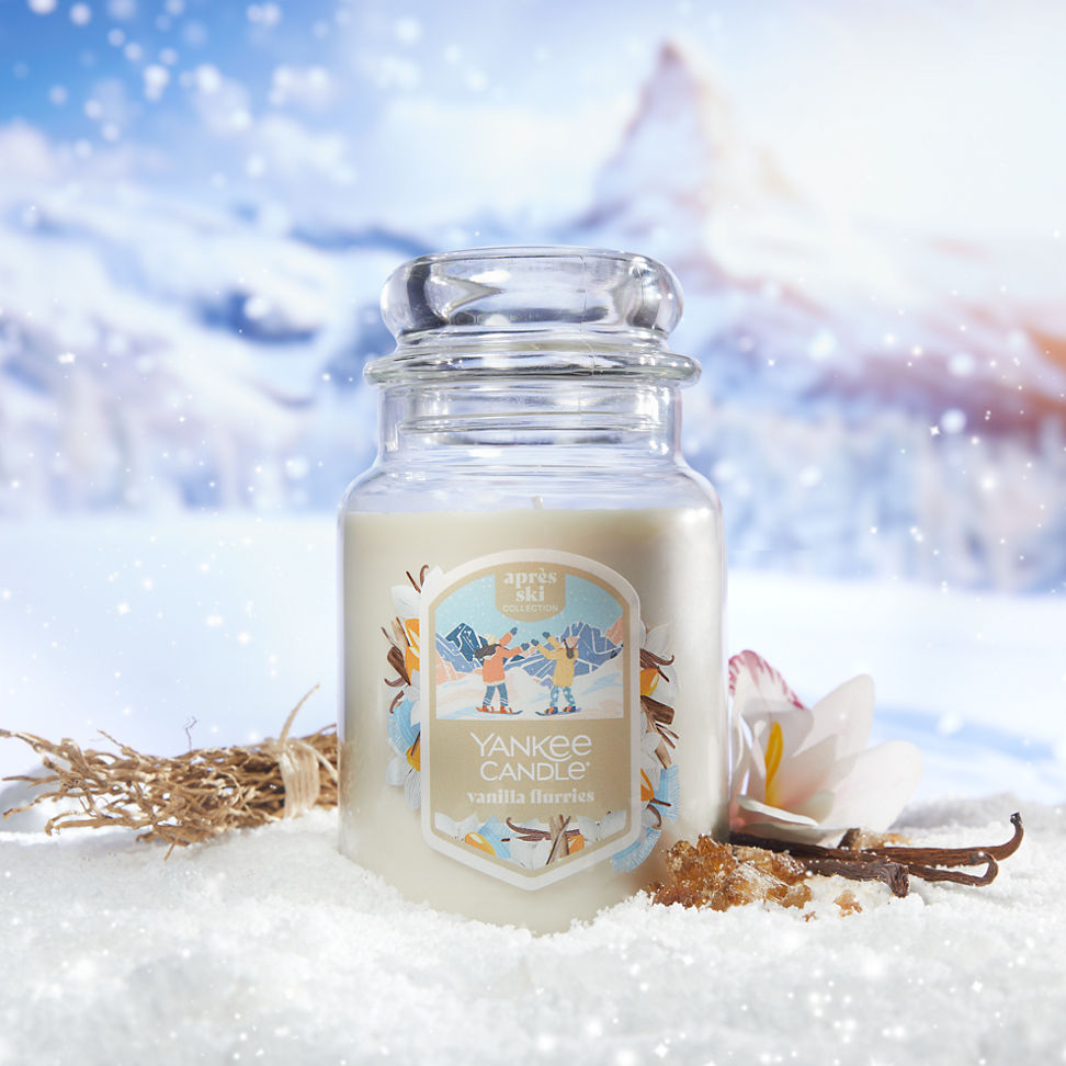 Apres Ski Collection Vanilla Flurries Original Large Jar Candle in snow surrounded by a flower, vanilla, and mountains