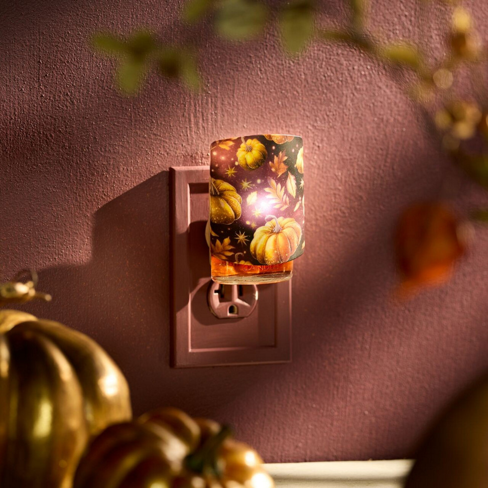 Plug-in night light with autumn pumpkin design glows warmly, perfect for cozy home fall decor ambiance