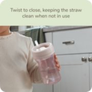 Child holding Nuk sippy cup with twist to close, keeping straw clean when not in use image number 3