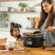 a woman and child cooking on table with slow cooker image number 2