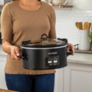 a woman holding a slow cooker of food image number 5