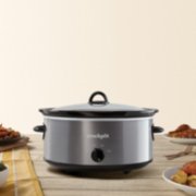 a stainless steel slow cooker with food on table image number 1