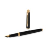 A Hemisphere fountain pen with gold trim laid next to an upright pen cap. image number 4