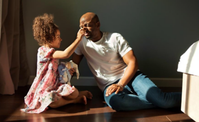 Two bronze bull statues positioned closely together, with a warm light casting shadows on their textured surfaces.