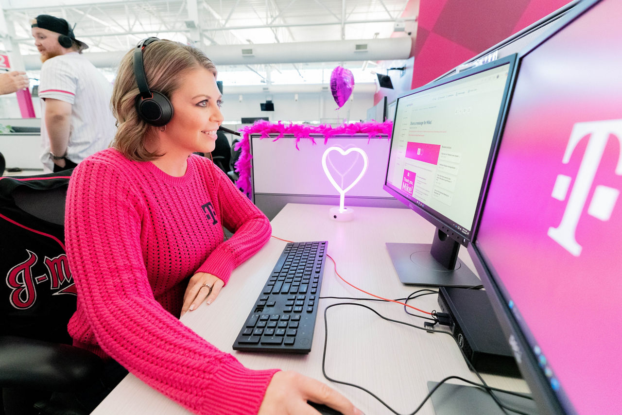 Employee wearing headset working at computer in T-Mobile office