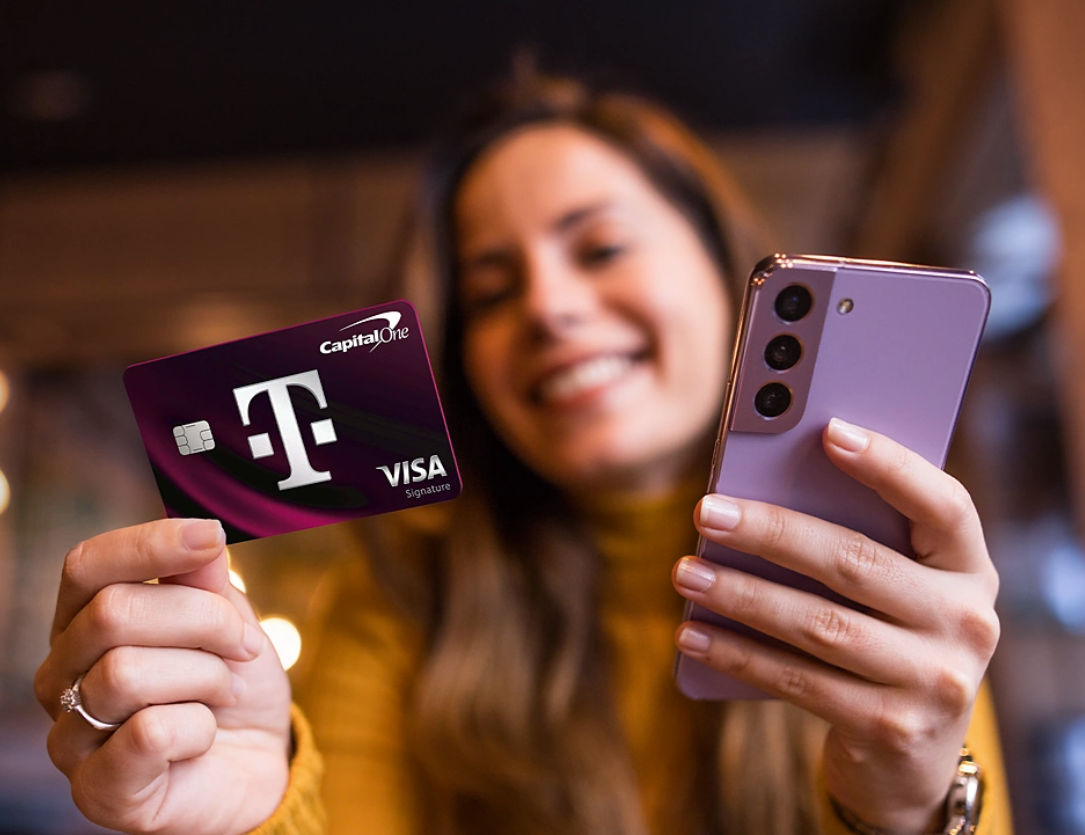 Woman holding a T-Mobile Capital One Visa card and phone.