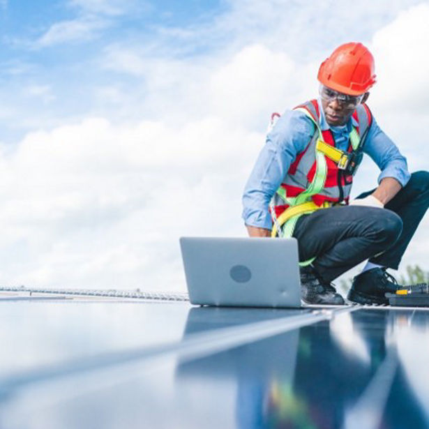 man in construction hat using a laptop