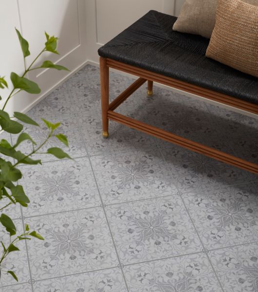 This floor features square porcelain tiles in a diamond layout that highlights the various shades of deep gray in the delicate floral pattern.