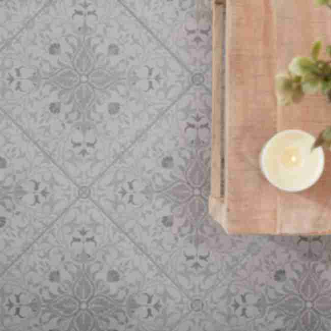 Patterned gray porcelain tile features a delicate tone-on-tone floral design that adds interest to this entryway floor without overwhelming the space or competing with other design elements.
