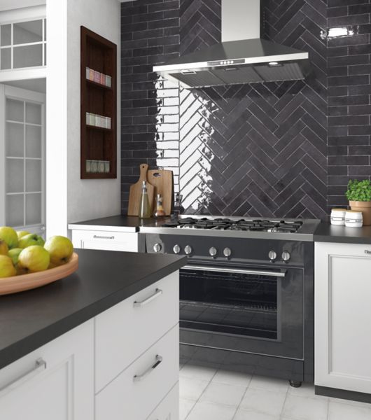 Sleek black elongated subway tile kitchen backsplash installed in a brick-lay and herringbone pattern.