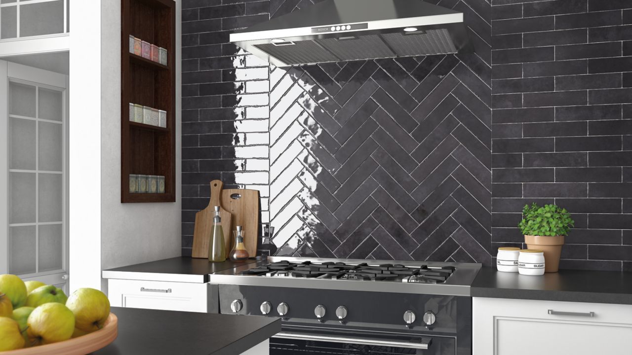 A modern kitchen with white tile flooring, white cabiners, gray countertopcs and glossy gray subway tile backsplash. The stove backsplash tile is laid in a herringbone style.
